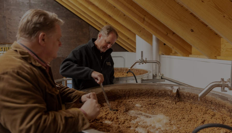 Two men stirring product