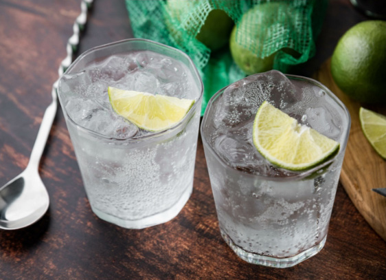 Two drinks with ice and limes